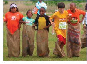 Photo of kids in a sack race at a Boys & Girls Club