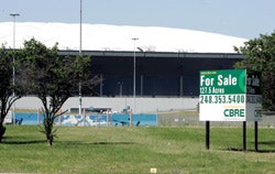 Photo of a For Sale sign in front of the Pontiac Silverdome, former home of the Detroit Lions.