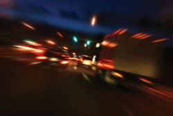 Blurred photo of cars driving along a highway at night illustrating the effect of driving under the influence