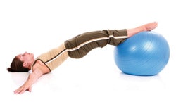 Photo of a woman balancing with her feet on an exercise ball