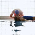 Photo of a lifeguard performing CPR on an unresponsive swimmer