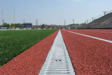 400-METER MAINTENANCE Removable grates provide access to the subterranean components of a channel drain system at any point along the track.