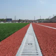 400-METER MAINTENANCE Removable grates provide access to the subterranean components of a channel drain system at any point along the track.
