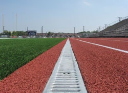 400-METER MAINTENANCE Removable grates provide access to the subterranean components of a channel drain system at any point along the track.