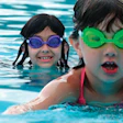 Photo of small children swimming in a public pool