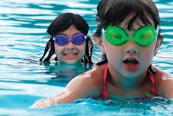 Photo of small children swimming in a public pool