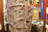 Photo of a woman scaling a large climbing wall