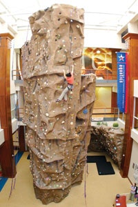 Photo of a woman scaling a large climbing wall