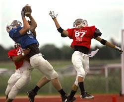 TEST SCORE Casey Nordine (in blue) of Rapid City Stevens pulls down a touchdown pass at the South Dakota All-Star game. Stevens is one of several schools in the state that implemented the ImPACT computer-based baseline testing program this season.