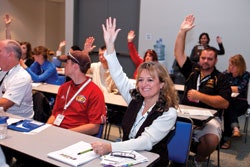 Attendees raise hands during a workshop