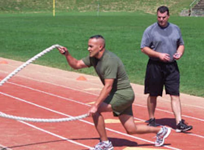 Maj. Robert Chapell's body posture and movements warm up his shoulder, core and quadriceps under the supervision of HITT developer Ryan Massimo. (Photo courtesy of United States Marine Corps)