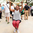 SWING SETS A woman tests out the equipment at the grand opening of the TPL Fitness Zone in West Perrine Park, Miami, Fla. (Photo courtesy of Tom Clark/TPL )