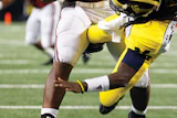 HARD KNOCKS As Alabama was pounding Michigan's Denard Robinson, Michigan State players were piling on via Twitter. (AP Photo/LM Otero)