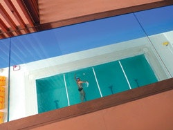 PRIME CUT The third-level entry lobby of Prime, an upscale club in Castel Maggiore, Italy, features a wide swath of glass inset into the resin lobby floor, giving members a view directly into the second-level pool. (Photo by Andrew Cohen)