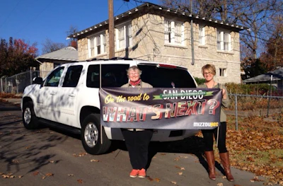MizzouRec staff memebers stop for a picture with their custom ABC banner outside the Bonnie and Clyde hideout house in Joplin.