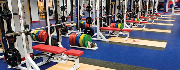 A NEEDED LIFT The days of simply installing 3⁄8-inch speckled rubber flooring in weight rooms are over as aesthetics, branding, performance and cleanability are prioritized in colleges and rec centers. (Univ South Methodist Weight Room)
