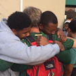 UAB football players embrace after learning that the school's football program would be shut down. Photo via @JonSolomonCBS on Twitter.