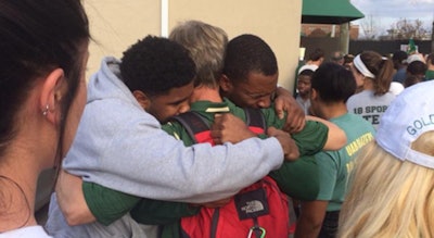 UAB football players embrace after learning that the school's football program would be shut down. Photo via @JonSolomonCBS on Twitter.
