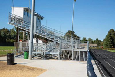 BIG SWITCH Hampton-Dumont’s conversion from wood bleachers to aluminum necessitated bringing the home-side stands up to ADA speed. - Click to enlarge