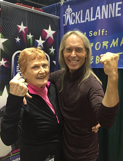 Elaine LaLanne and her son, Jon, do the famous Jack LaLanne muscle pose in their booth at the IDEA World convention last July in Los Angeles. (Photo by Stuart Goldman.)