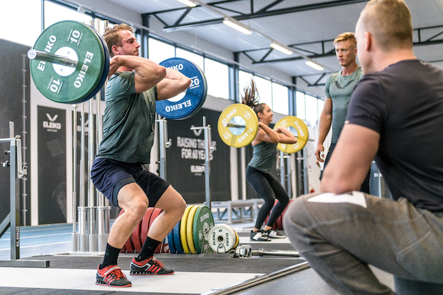Two weightlifters on weightlifting platforms.