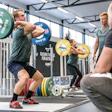 Two weightlifters on weightlifting platforms.