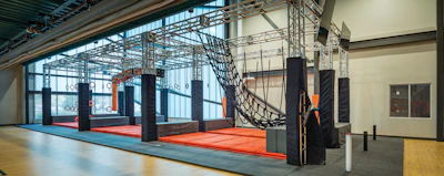 The City of Westerville has moved fitness into the fun zone by taking advantage of a recent expansion of OH Community Center to add an indoor adventure course. The course measures 58 feet long by 16 feet wide and stands 13 feet high. It occupies nearly 2,000 square feet of space — including circulation clearance, bonded-foam carpet and 4-inch-thick crash mats — and is comprised of various ropes, rings and handhold challenges, as well as stop and start buttons and TV monitors that track and display the best course-completion times for each day.