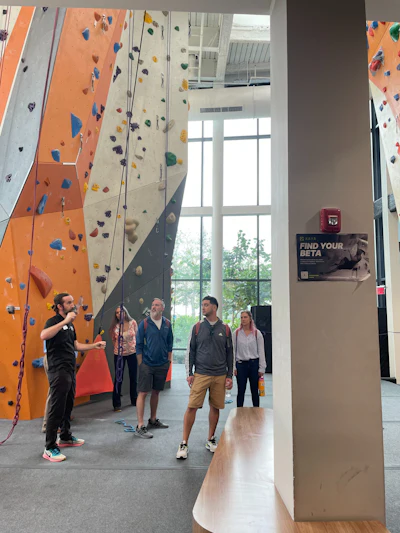 Tour attendees learn more about the climbing wall area at a facility during an AB Show Orlando tour in 2022.