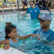 U.S. Olympic Gold Medalist, Cullen Jones, helps students learn water safety skills at the Valley of The Sun YMCA/Leslie's World's Largest Swimming Lesson event in Phoenix, Ariz.