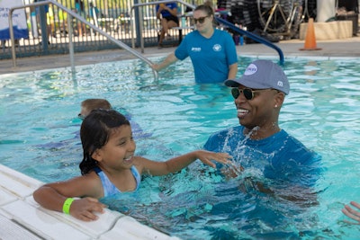 U.S. Olympic Gold Medalist, Cullen Jones, helps students learn water safety skills at the Valley of The Sun YMCA/Leslie's World's Largest Swimming Lesson event in Phoenix, Ariz.