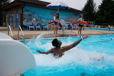 Two lifeguards watch over swimmers at the Douglass Park pool in June 2022 in Indianapolis, which suffered a lifeguard shortage last year. Many states and cities suffering similar shortages have made major changes in how they train, recruit and compensate lifeguards.