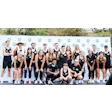 Fitness team in black athletic wear posing together on branded stage