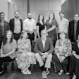Professional team photo with 11 colleagues in black and white, seated and standing