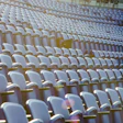 Empty stadium seating with white and blue chairs in precise rows