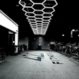 Dark fitness gym with geometric white hexagon lights and fitness equipment