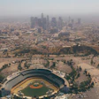 Aerial view of Dodger Stadium with Los Angeles downtown skyline in misty background