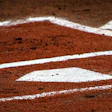 Baseball field corner with white foul lines on reddish clay surface