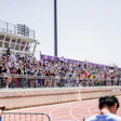 Packed stadium bleachers overlooking a running track during a sports event