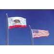California state flag and US flag flying together against blue sky