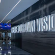 Modern interior with illuminated wall text 'Create Your Own Vision' in sleek fitness space