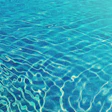 Rippling turquoise water surface with intricate light and wave patterns