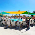 Crowded water park with colorful shade canopies, swimming pool, and water slides