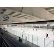Indoor hockey rink with players skating, flags, and organizational logo banner