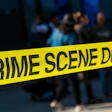 Yellow crime scene tape blocking an area with blurred people in background