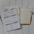 Paperwork and notebook with pen on white wooden background