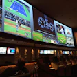 Sports bar with multiple screens showing live baseball, tennis, and sports broadcasts