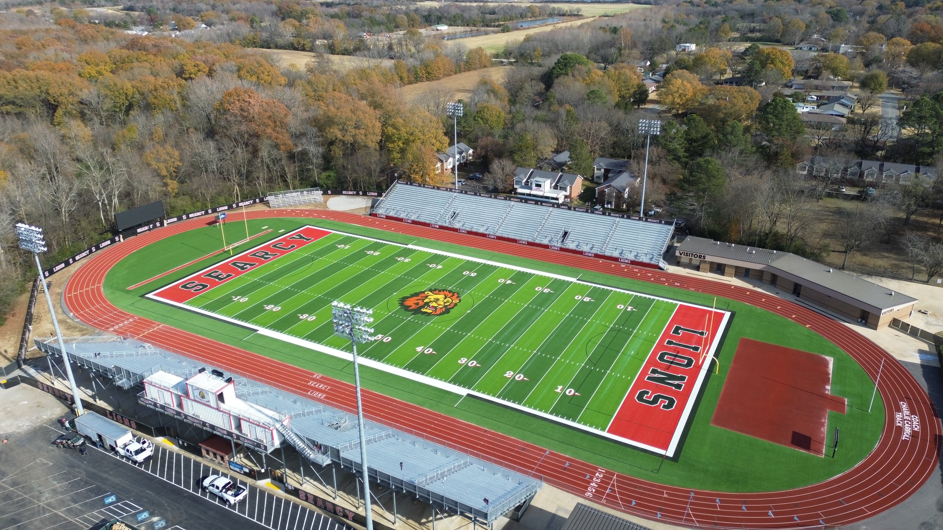 Aerial view of a high school football stadium with red track and green field