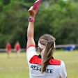 Referee with raised hand signaling during outdoor sports match