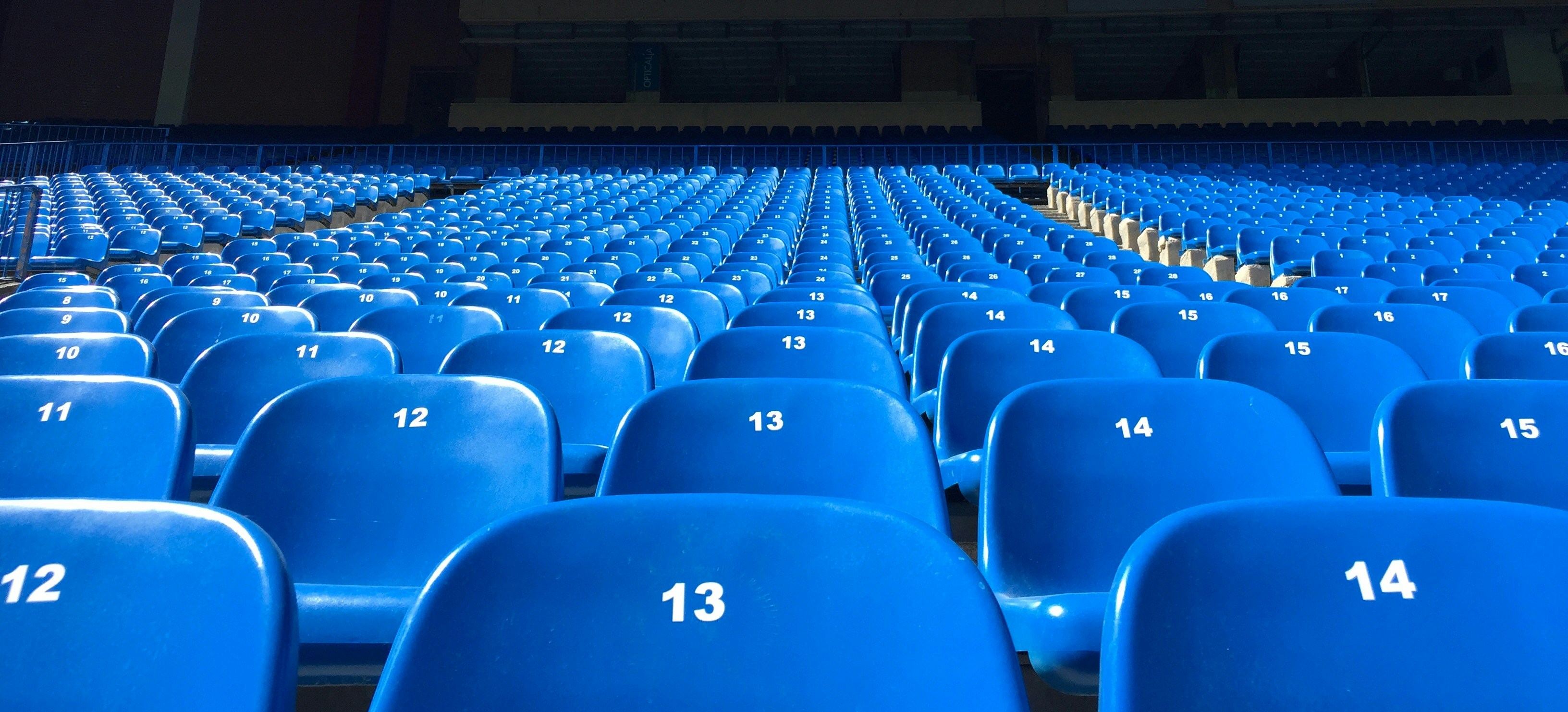 Empty blue stadium seats with white numbered rows