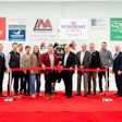 Corporate ribbon-cutting ceremony with group of professionals on red carpet